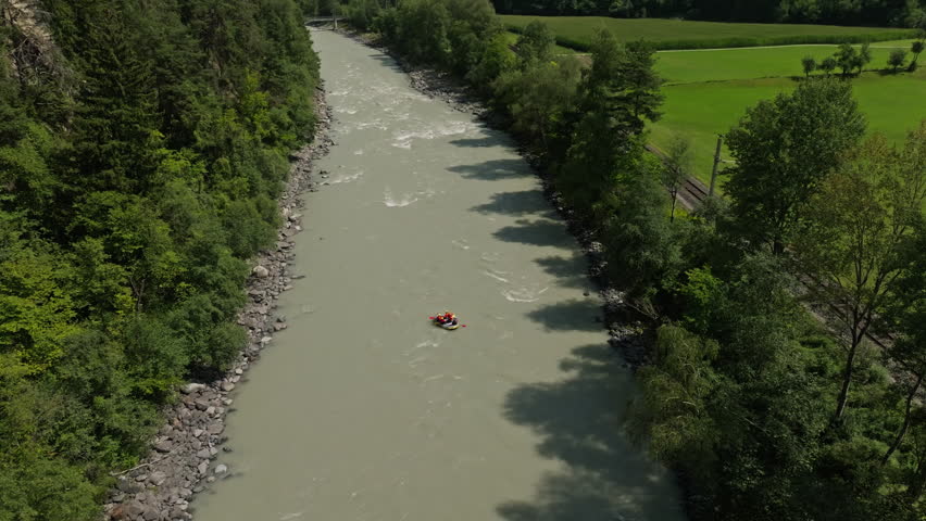 Scenic aerial view of whitewater rafting in Austria with inflatable boat crossing river rapids among breathtaking alpine landscapes of Tyrol