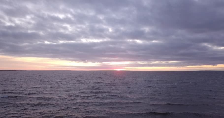 Flying over a choppy river in the evening at sunset on a cloudy evening