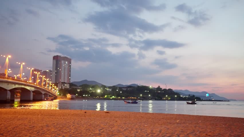 Illuminated bridge and beachfront skyline at dusk