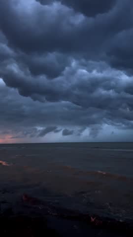 Dusk over turbulent sea with orange hues. Majestic dusk sky and crashing waves