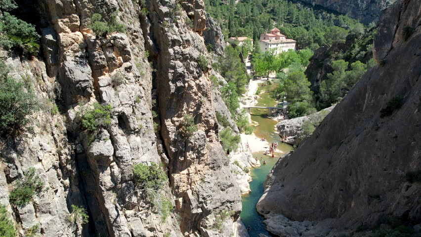 Sliding aerial shot of La Fontcalda swimming area and Canaleta River on sunny summer day. Gandesa, Tarragona, Spain.
