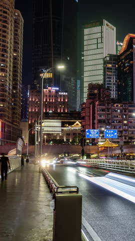 CHONGQING, CHINA - 28 MAY 2026: Timelapse of the amazing Chongqing cyberpunk city skyline from the Qiansimen Bridge at night in vertical