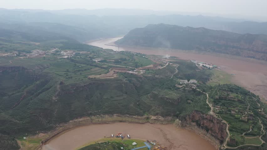 Aerial video footage of the scenic Yellow River flowing through dramatic canyons and sandstone cliffs in Inner Mongolia, China.