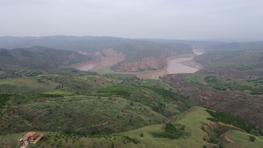 Aerial video footage of the scenic Yellow River flowing through dramatic canyons and sandstone cliffs in Inner Mongolia, China.
