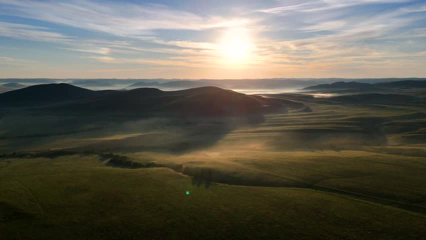 Landscape with green mountains, mist at dawn, and clouds