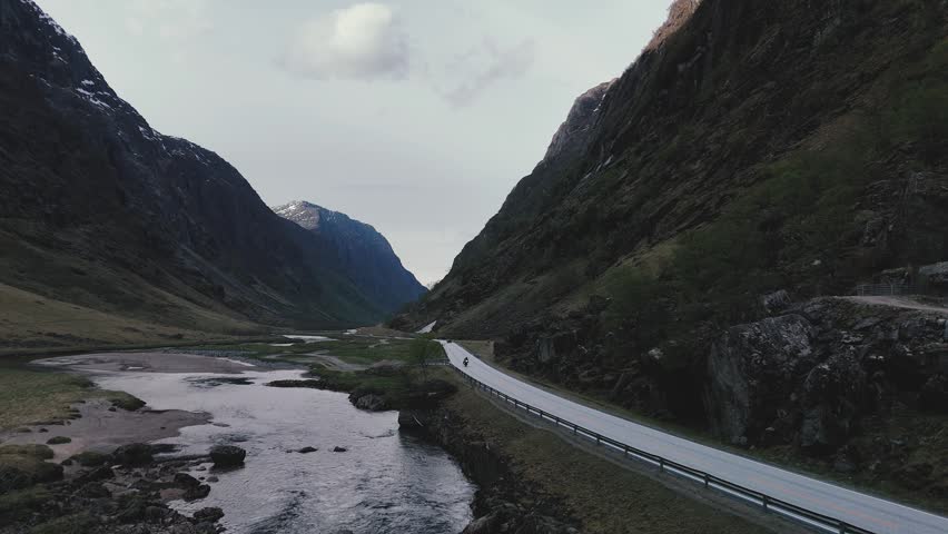 Aerial tracking shot of a road in a mountain canyon