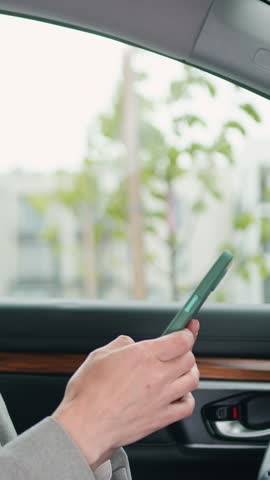 Smiling blond woman chatting or browse videos or photos or social networks on smartphone while sitting in car. Slow motion.