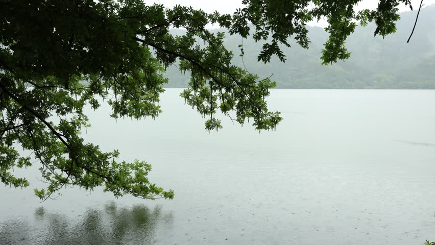 Rain falling over a lake in natural outdoor landscape