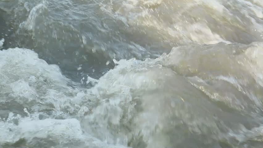 strong water flow in a rocky river in the afternoon