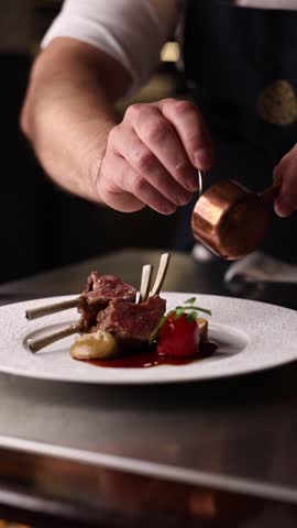 Chef preparing grilled New Zealand lamb ribs in a premium restaurant kitchen. Close-up of juicy meat, fire grill and gourmet cooking process.