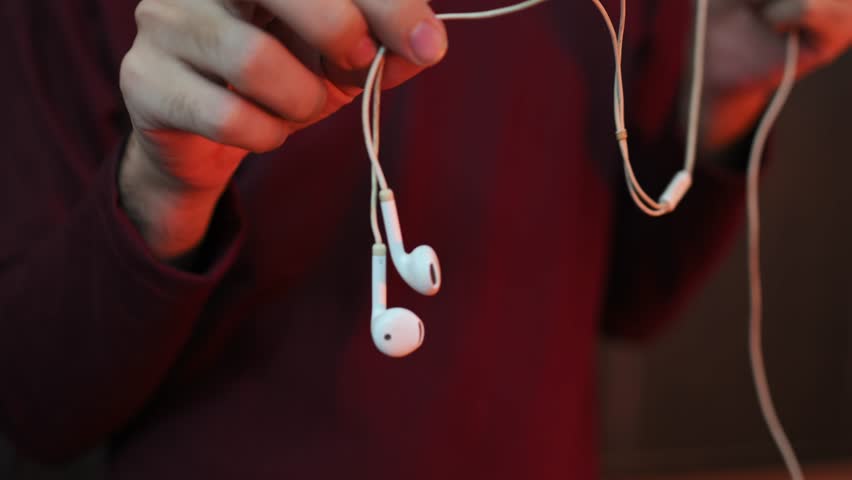 Macro Shot of White In Ear Headphones Hanging from Cable