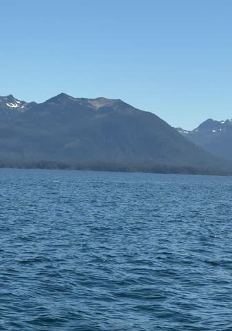Humpback whale surfacing, exhaling, and lifting its tail fluke before diving in the waters near Sitka, Alaska.