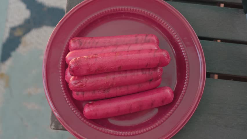 Grilled bright red hot dogs on a plate