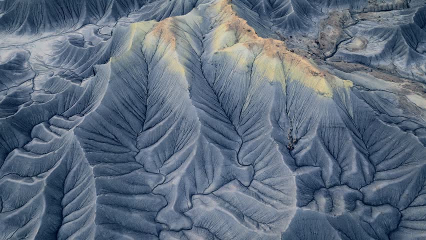 Aerial view of the intricate eroded ridges and grey shale formations of Factory Butte in the desert landscape of Wayne County, Utah, United States.
