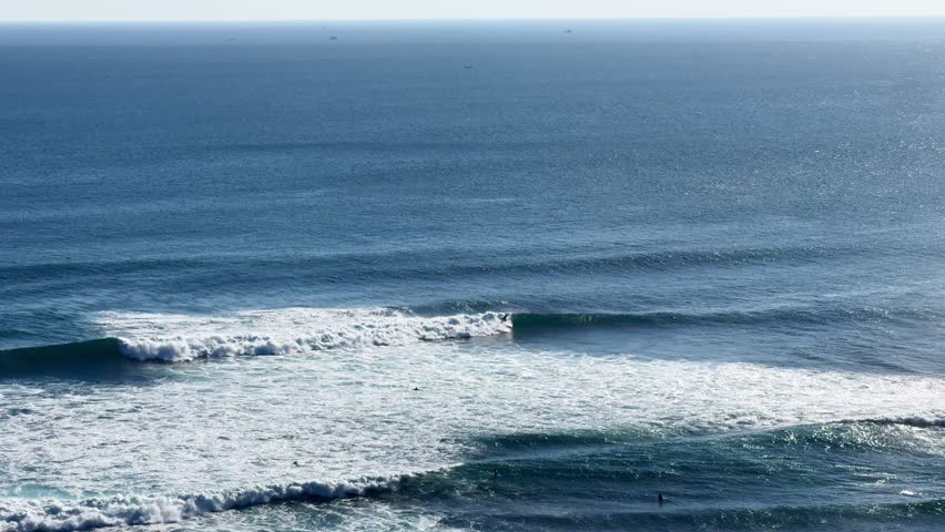 Surfers riding waves in the open ocean