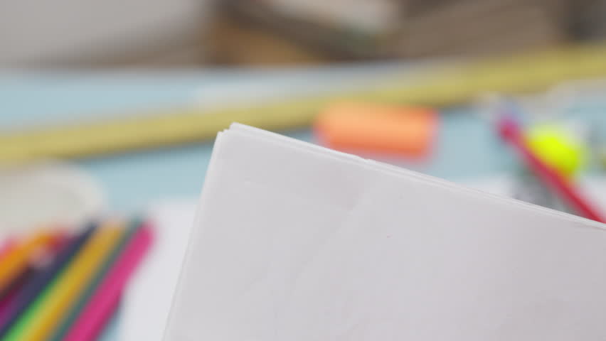 Close-Up of a Hand Securing Papers with a Pink Binder Clip, Perfect for Back to School, School Supplies, Office Organization, Classroom, and Student Learning