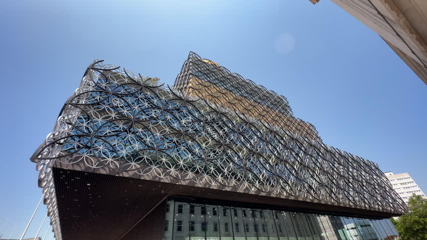 Low-angle architectural tilt up video showcasing the unique, contemporary exterior of the Library of Birmingham in Centenary Square, England, UK