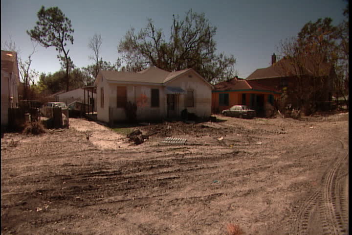 Damaged homes and yards filled with silt near 17th Avenue, camera pans right to more wrecked houses and broken tree in New Orleans after Hurricane Katrina.