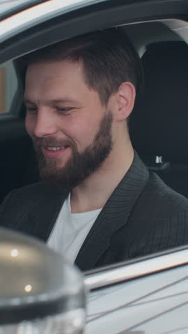 Vertical Video Sales manager handing over the keys to man that sitting in the car.