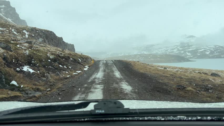 POV Of Driver Driving On An Icy Road Alongside A Fjord In Djupavik, Iceland.