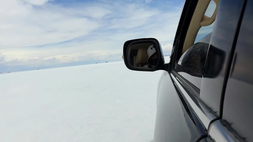 4x4 vehicle exploring the vast white desert of Salar de Uyuni, Bolivia