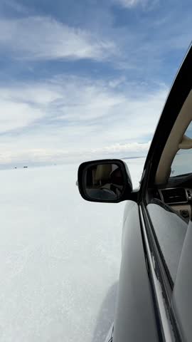 4x4 SUV driving across Uyuni Salt Flat Bolivia