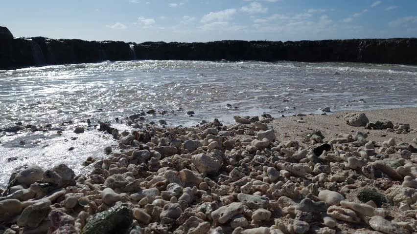 Ocean wave splashing over rocks on a coral shore