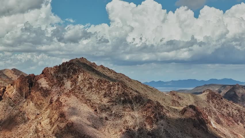 Rocky mountains under a sky filled with clouds in the USA. The landscape stretches into the distance, capturing the rugged terrain and vast open space.