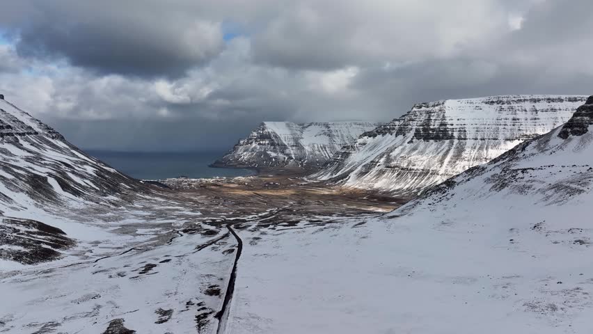 Snow-covered Bolafjall Mountain Near The Fishing Town Of Bolungarvik In The Westfjords Of Iceland. - aerial shot