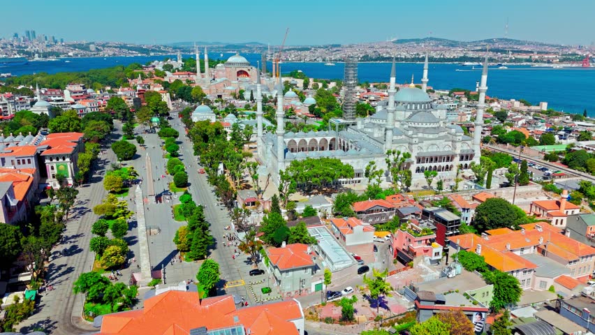 Drone view of Sultanahmet district in Istanbul, Turkey. Hagia Sophia Grand Mosque stands near red rooftops, gardens and historic city buildings.