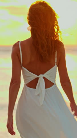 Portrait of beautiful happy woman in white and curly hair at beach at sunset, outdoor on holiday in summer. Woman with smile at vacation in paradise island Mauritius