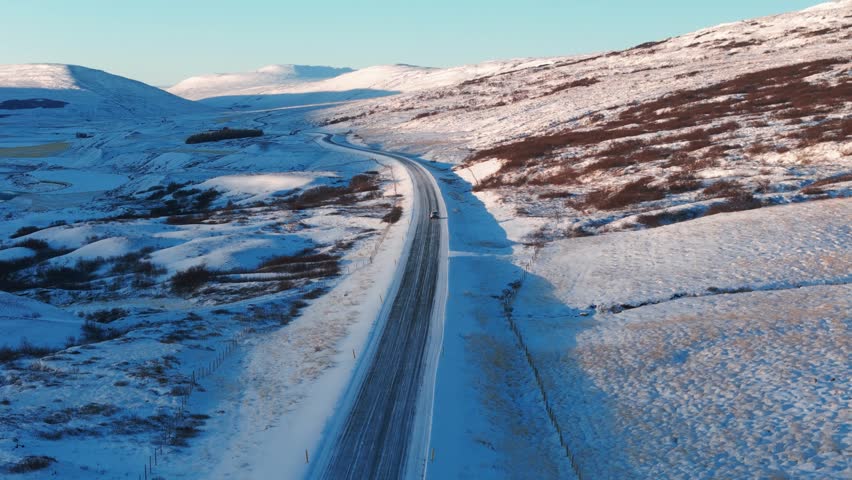 Aerial view of car driving on snow covered road in Iceland