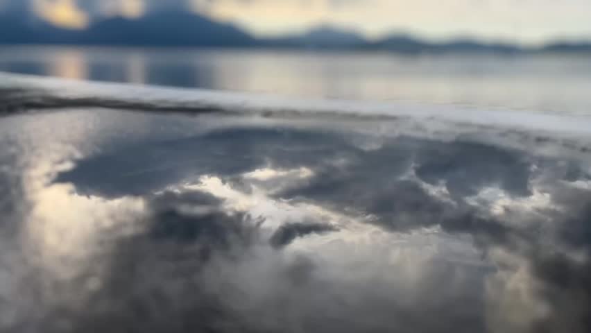 Calm puddle reflecting the clouds and the sky after the rain