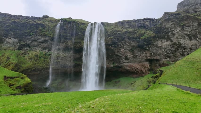 The famous Seljalandsfoss waterfall in Iceland with powerful water plunging from the cliff. A beautiful natural landmark and tourist attraction