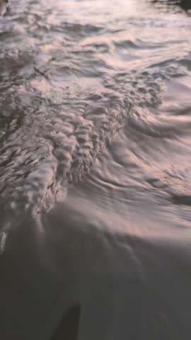 Gentle water ripples forming across the surface before sunrise, creating a peaceful scene that captures the natural beauty and tranquility of the early morning atmosphere