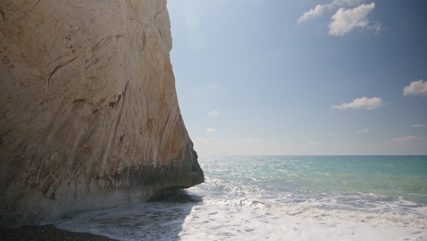 Dramatic view of a large cliff face meeting the sea at Aphrodite