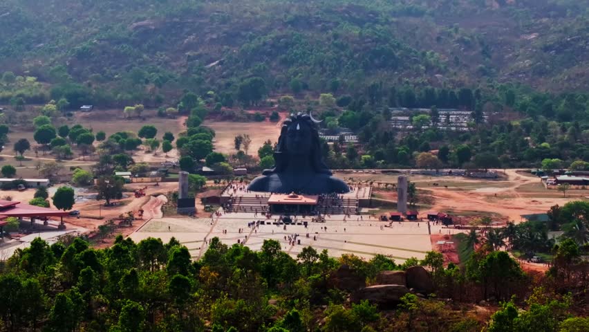 112-ft Adiyogi statue with mountain trees and people at Isha Foundation, Agalagurki Village, Chikkaballapur, Bangalore, karnataka, india. day time, trucking shot, drone shot, 4k.