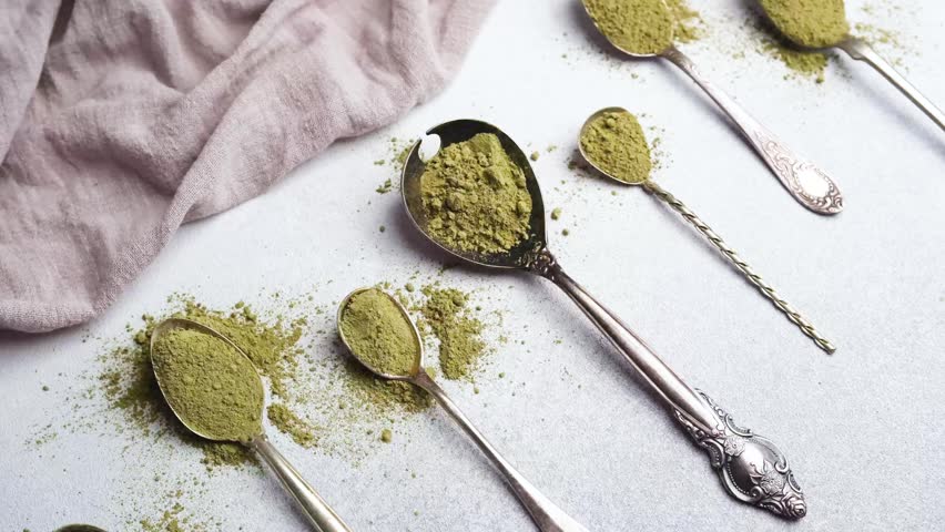 Matcha powder on spoons arranged on a surface