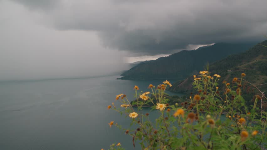 Stormy rain clouds hovering over a beautiful lake and mountains.