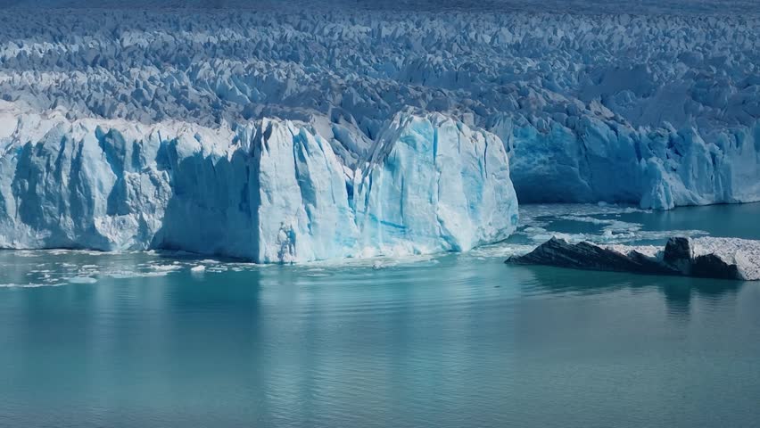 Towering ice walls at Perito Moreno Glacier in Patagonia, Argentina, as a massive block of ice breaks off and crashes into the water, showcasing one of El Calafate’s most iconic natural wonders