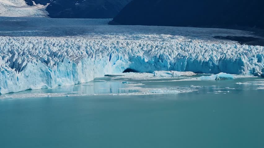 Towering ice walls of the Perito Moreno Glacier rise dramatically in Los Glaciares National Park near El Calafate, Argentina under clear sunny skies, Patagonia’s most iconic natural tourist attraction