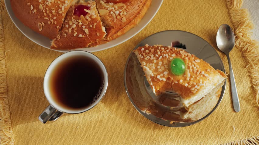 Cake Roscon de reyes with cup of black tea on the table. A traditional pastry prepared and served on the Feast of the Three Kings or Epiphany in Spain. High quality 4k footage