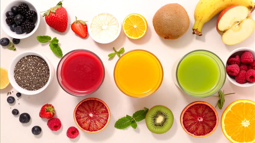 A variety of colorful fruit juices and sliced fruits on a table