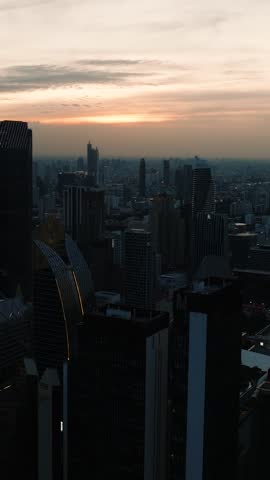 Dusk over Bangkok city with tall buildings creating a dense and urbanized skyline under colorful skies. Bangkok, Thailand.