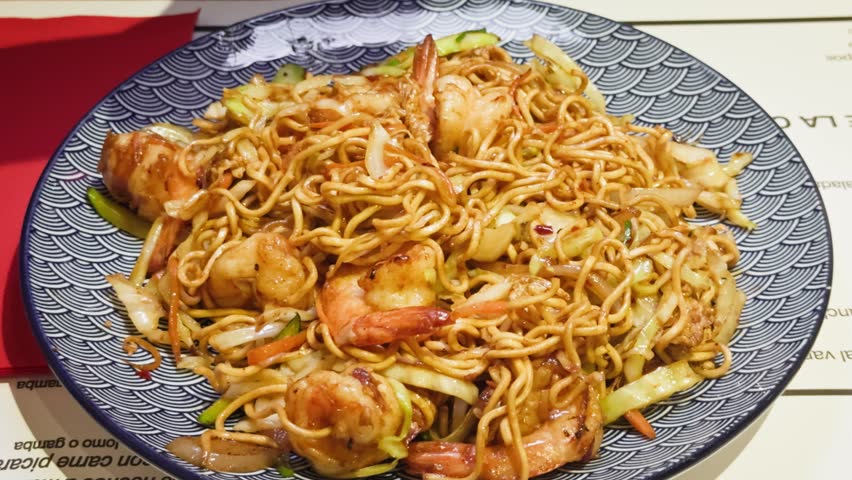 Stir-fried spicy noodles with vegetables and shrimps. High quality 4k footage