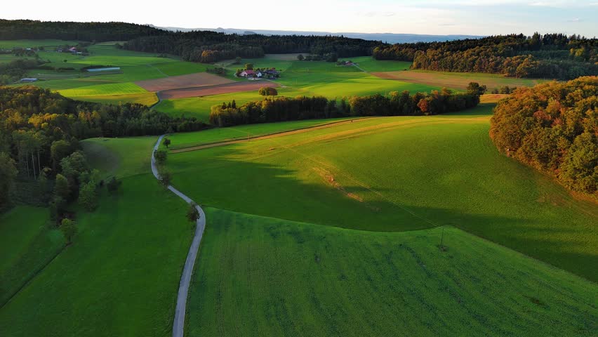 Aerial Drone Flight Over Green Fields at Golden Hour Sunset