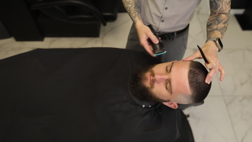 Professional barber giving haircut to male client