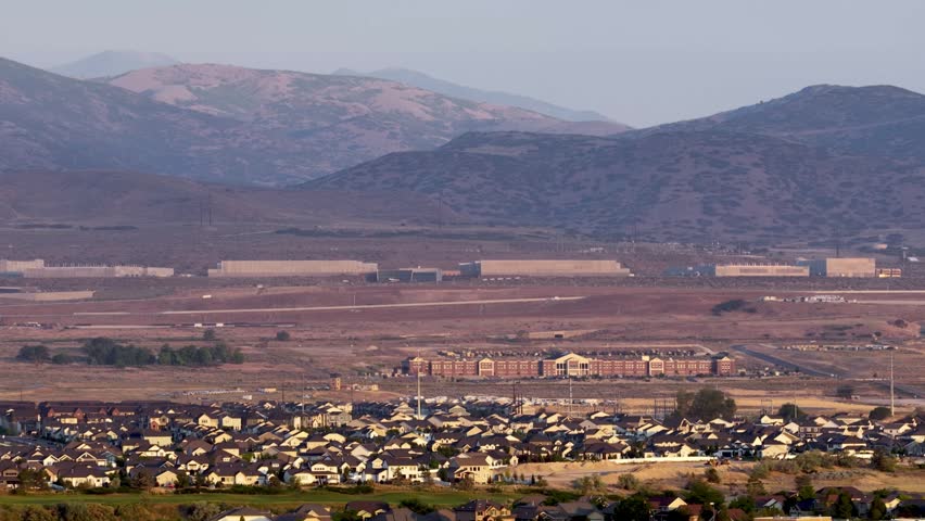 Lehi, Utah with Camp Williams and the NSA Data Center at the foot of the Oquirrh Mountains - sliding aerial view on a hazy day