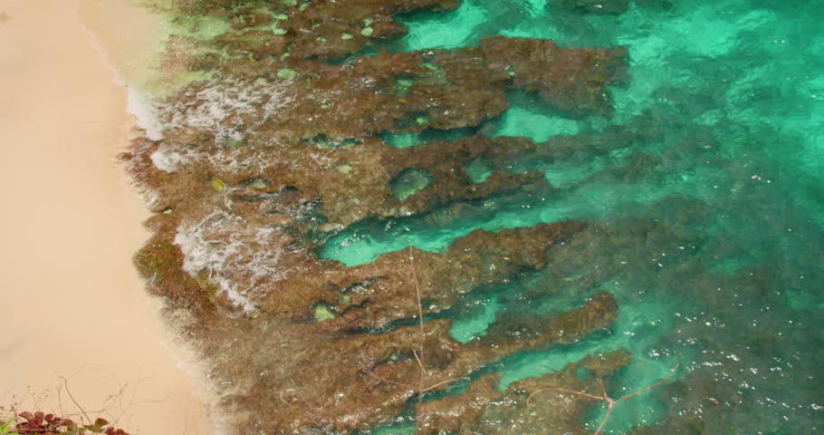 Rocky shoreline with sandy beach and shallow turquoise water