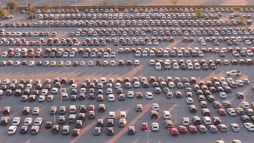 Large modern car dealership lot in Florida with rows of new and used vehicles, shiny inventory displayed outdoors under sunset light. Automotive retail and consumer choice.